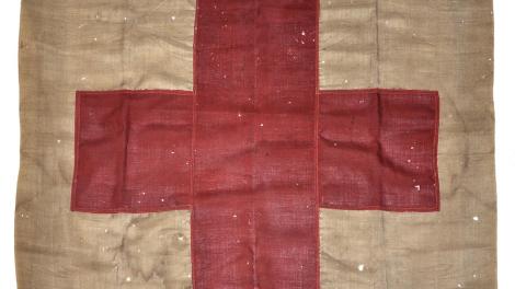 "100 year old flag with red cross symbol."